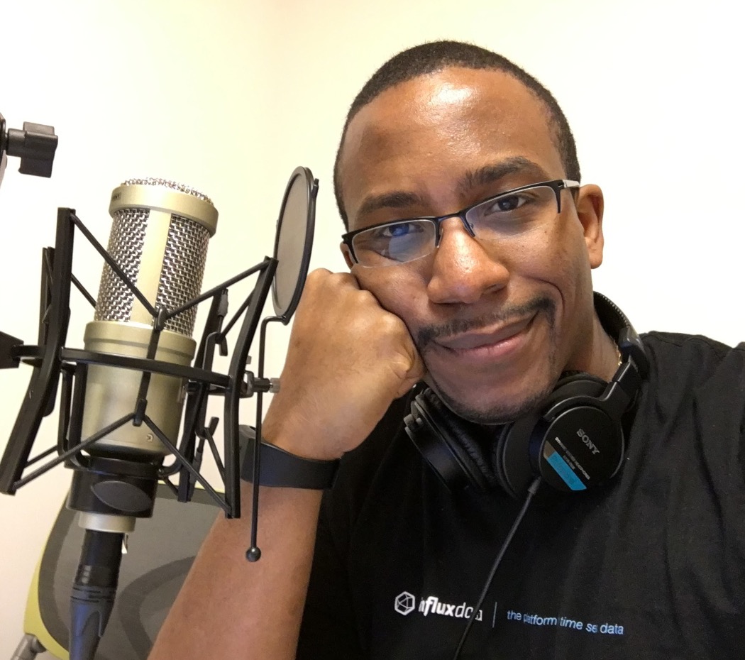 Johnny beside a studio microphone wearing headphones